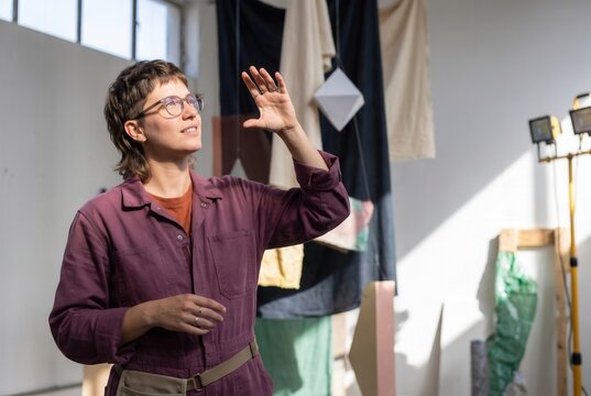Female artist thinking about new ideas and creating art in a bright workspace