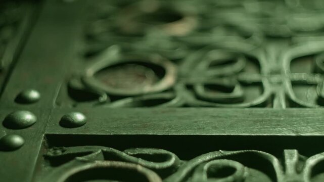Ancient alien figurine resting inside ornate metal casket with intricate carvings under moody green atmospheric cinematic lighting.
