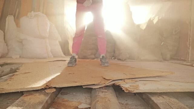 Golden backlight reveals falling sledgehammer amid drifting dust, hard labor