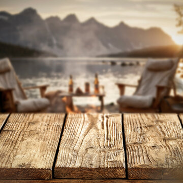 Lake camping with mountain view and wooden table with copy space &ndash; outdoor summer adventure concept.
