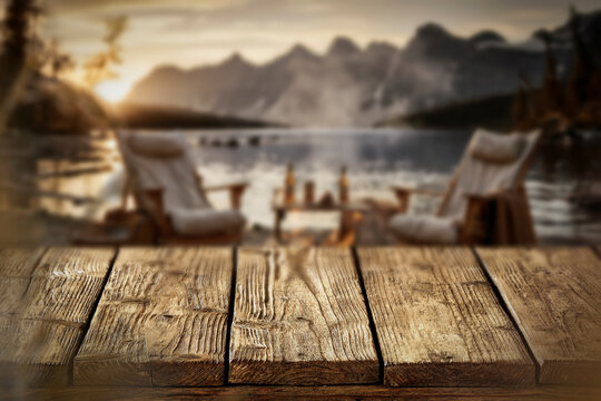 Lake camping with mountain view and wooden table with copy space &ndash; outdoor summer adventure concept.
