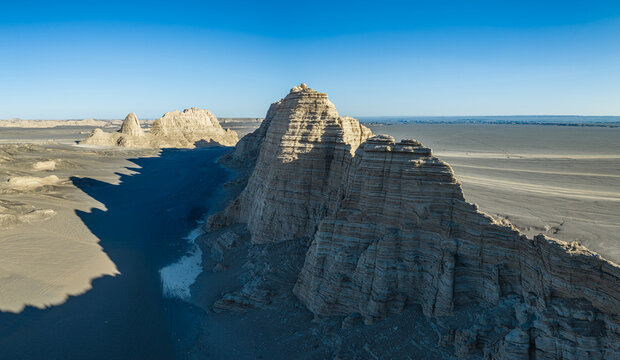 Majestic yardang rock formations rising from the desert floor under a clear blue sky, Dahaidao, Xinjiang, China