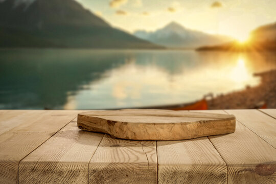 Empty wooden table with clean copy space for product placement with lakeside scenery background, warm and sunset mountain outdoor setting.