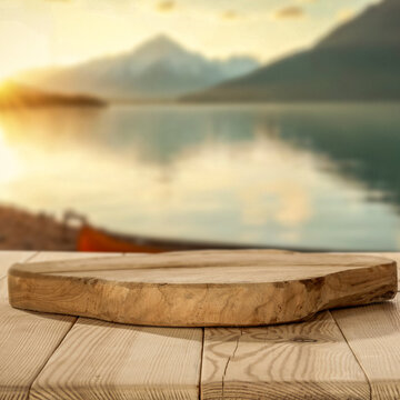 Empty wooden table with clean copy space for product placement with lakeside scenery background, warm and sunset mountain outdoor setting.