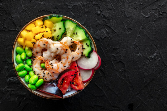 Poke bowl with shrimps, tomatoes, cucumber, mango, edamame, overhead shot