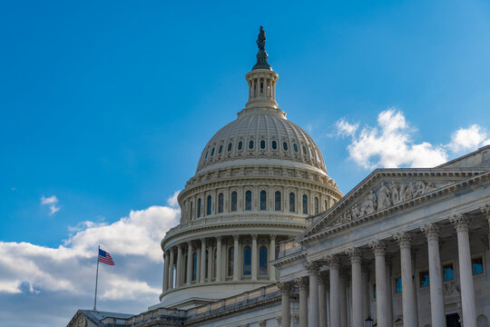 Capitol dome. Historic Capitol by the national flag. Capitol dome as symbol of law. Washington monument architecture. Washington DC. US Senate. Federal government in the nation capital