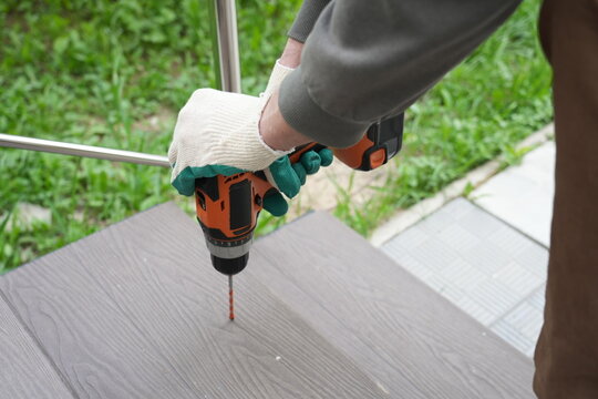 Drilling hole in wooden terrace board close-up