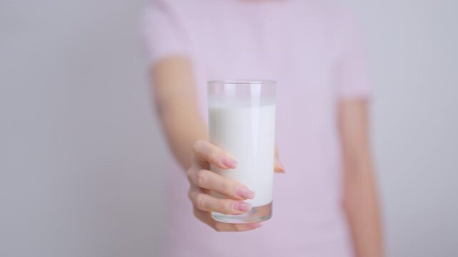 Healthy woman holding glass of fresh milk at home, female drinking milk for calcium and strong bones, high protein, dairy product for healthy lifestyle, wellness and daily routine concept
