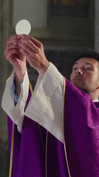 Elevation of the Host during the Consecration in a Catholic Mass, the priest raising the Eucharistic bread after speaking the words
