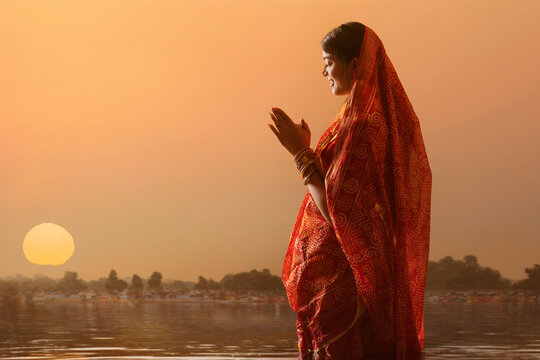woman from Bihar offers prayers to the  sun  in the  early morning hours during  Chhath Puja festival
