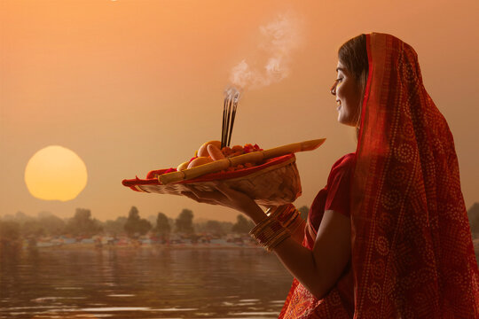 woman from Bihar offers prayers to the  sun  in the  early morning hours   during  Chhath Puja festival
