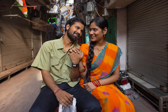 Romantic couple riding a rickshaw with holding their hands together