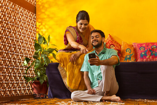 Portrait of Gujrati couple using mobile phone