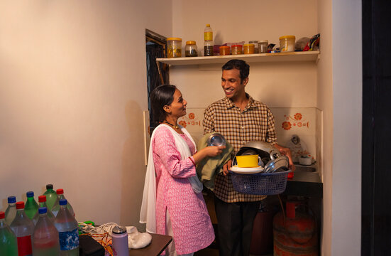 Husband helping his wife with housework in the kitchen