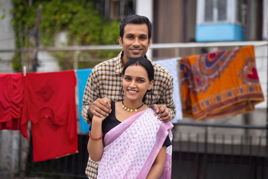 Portrait of happy young couple standing together in the backyard