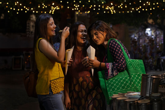 Women having fun while eating Jhalmuri at roadside stall