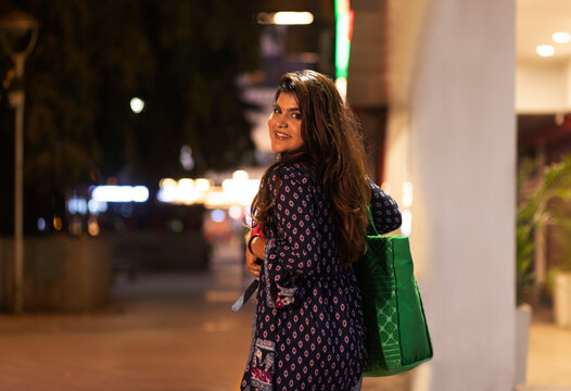 Woman looking back at camera with smile while walking on street