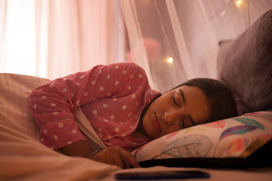 Portrait of a teenage girl sleeping on bed
