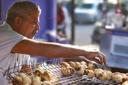 Male vendor making litti at his roadside food stall