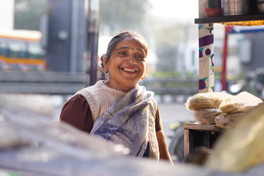 Portrait of a smiling female vendor at her roadside food stall