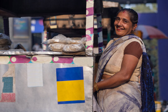 Portrait of a smiling female vendor at her roadside food stall