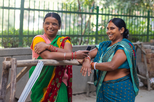 Two maids standing and chatting on the street 
