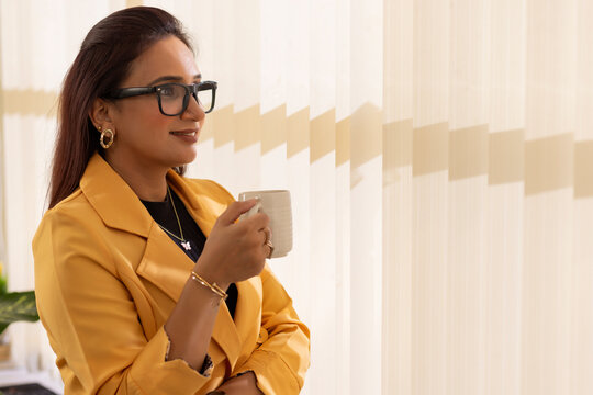 Portrait of a businesswoman holding a cup of coffee and looking away