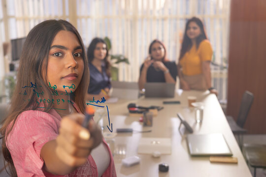 Businesswoman giving business presentation with graph in conference room 