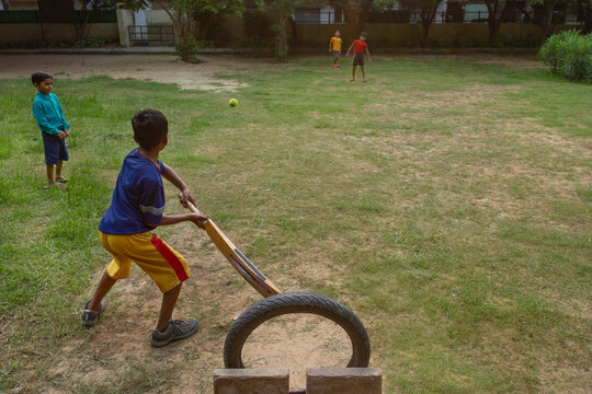 Portrait of boy hitting a shot while playing cricket in the park