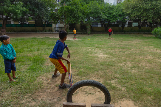 Pre-adolescent boys playing cricket in the park
