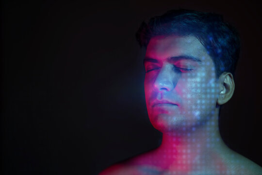 Close-Up Portrait Of Young  man With Closed Eyes and neon light falling on is face