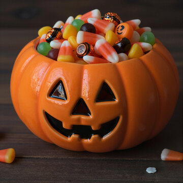 festive halloween candy bowl filled with assorted sweets and candies in a pumpkin-shaped container
