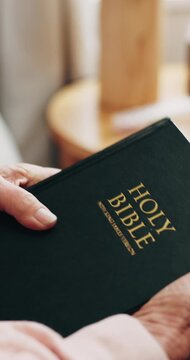 Senior person, home and hands with bible, faith and worship with holy scripture or spiritual belief. Praise, God and pensioner with book for Christianity, knowledge and Jesus Christ guidance in house