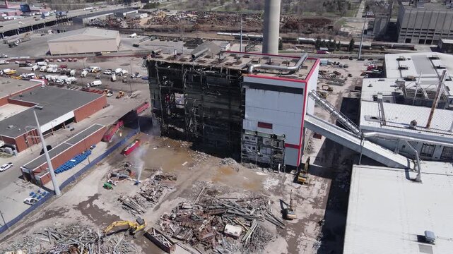 Aerial view of demolition site with excavators and building rubble during industrial plant deconstruction process.