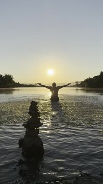 Dynamic Water Splash by Man in a Mystical Sunrise Lake