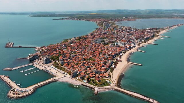 Pomorie peninsula aerial drone view coastal town red tile roofs sandy beaches Black sea bay Bulgaria summer sunny travel destination resort background.
