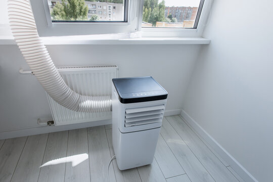 Smart mobile monoblock air conditioner unit operating on laminate floor with flexible exhaust duct vent