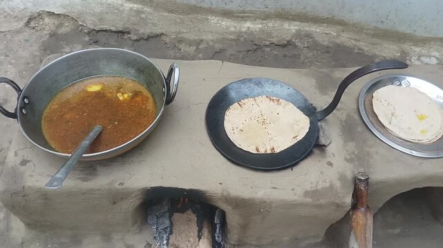 Traditional Indian Roti and Curry Cooking on Mud Chulha