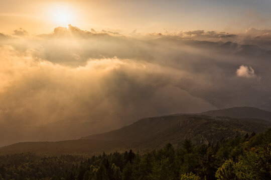 Sunset illuminates the dramatic mountain landscape above the clouds, highlighting a tourism destination in Monte Baldo Natural Park, Brentonico, Trentino, Veneto, Italy.