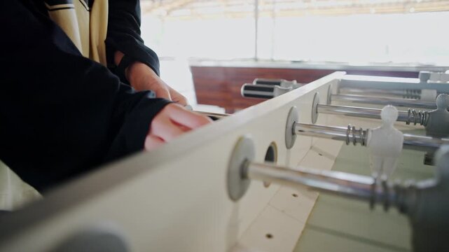 Teenage Girl Masterfully Playing Foosball With Parents Prepares To Start A New Game With The Ball