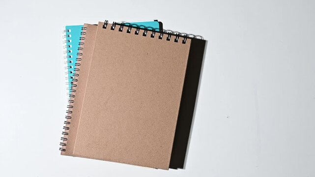 Blank spiral notebooks on white surface with dramatic light transition