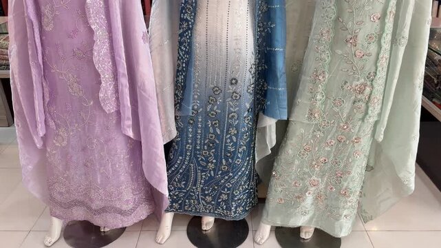 Shararas, ghararas, and straight suits displayed on rowed mannequins in a Pakistani boutique showroom.