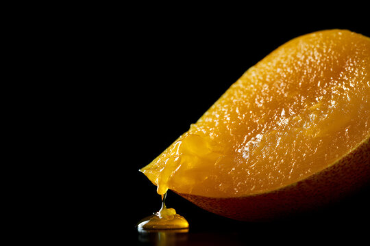 Sliced ​​mango on a black background, juicy vibrant flesh, texture