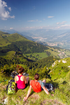 Hikers enjoy panoramic views on a mountain trail, exploring outdoor freedom in Corna Piana Botanical Reserve, Monte Baldo Natural Park, Brentonico, Trentino, Veneto, Italy.