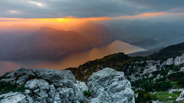 Mountain landscape overlooking Lake Garda at sunset, showcasing rugged rocky peaks and outdoor tourism exploration, Altissimo Refuge, Monte Baldo Natural Park, Brentonico, Trentino, Italy.