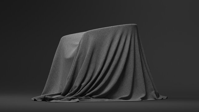A dark, textured fabric-covered object stands against a plain black background with soft folds on its surface. Copy space. 