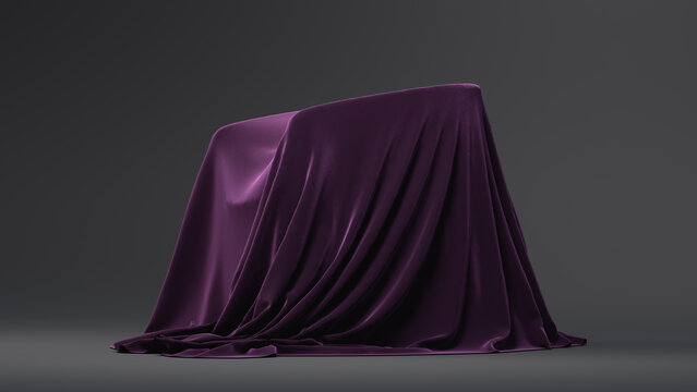 A dark purple, textured cloth-covered object rests on a plain gray background with soft folds of fabric draping down to the floor. Copy space. 