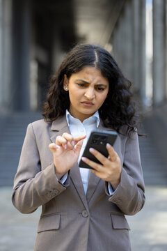 Businesswoman experiencing confusion using smartphone with technology issues