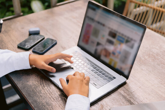 Close up of hands using laptop computer for online work outdoor