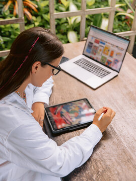 Woman working with laptop and tablet in outdoor cafe. workspace